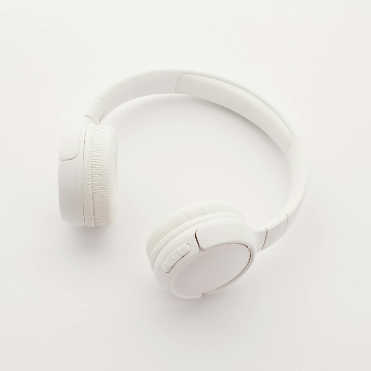 Sleek overhead view of modern white wireless headphones on a clean white background.